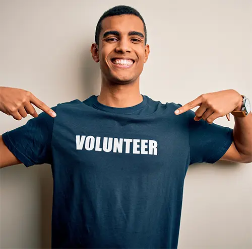Smiling man pointing at volunteer t-shirt