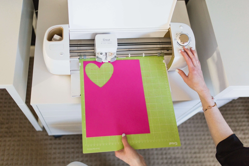 Craft machine cutting pink paper heart